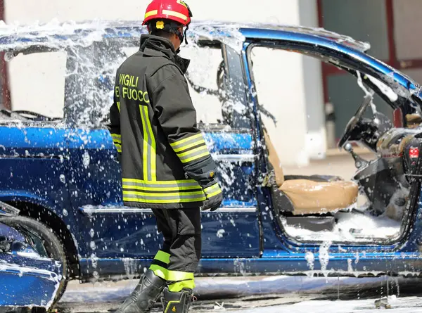 Vicenza, VI, İtalya - 23 Mayıs 2024: Araba kazasından sonra kaza yapan İtalyan itfaiyeci beyaz köpükle kaplandı