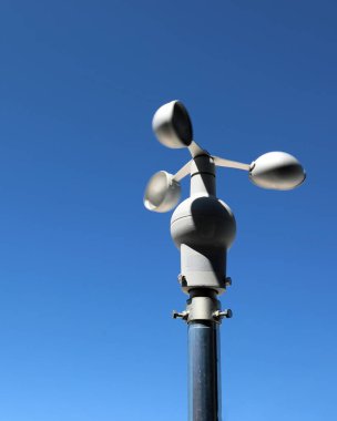 Rüzgâr hızının tam ölçümü ve kaydedilmesi için üç yarıküreye sahip anemometre ve insansız mavi gökyüzünün arka planı