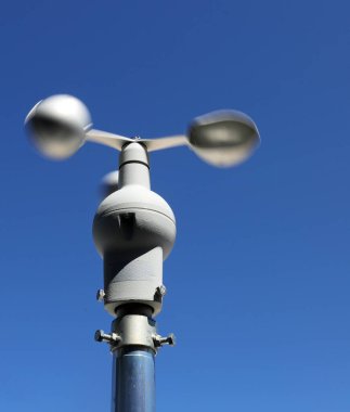 Rüzgâr hızının tam ölçümü ve kaydedilmesi için üç yarıküreye sahip modern anemometre ve insansız mavi gökyüzünün arka planı