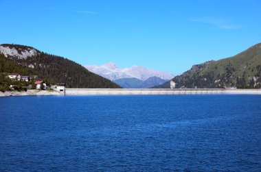 Kuzey İtalya 'da Lago di Fedaia adlı yapay gölün beton barajı ve arka planda Dolomitler