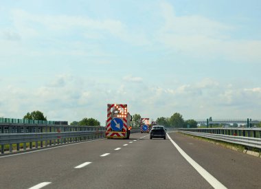 Otoyol şeridindeki yol çalışmalarını gösteren dev bir okla çalışan bir minibüs.