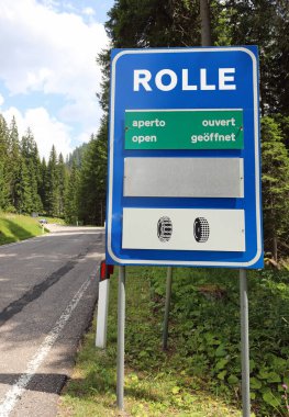 large road sign with the writing Rolle indicating the location of the mountain pass open during the summer season the snow chain symbol in ITALY clipart