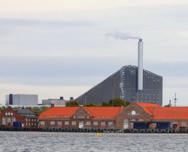 Copenhagen, COP, Denmark - August 23, 2024: Amager Bakke or Copenhill is a heat and power waste-to-energy plant and recreational facility clipart