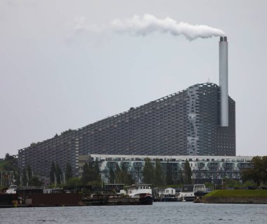 Copenhagen, COP, Denmark - August 22, 2024: Amager Bakke or Copenhill is a  heat and power waste-to-energy plant and recreational facility clipart