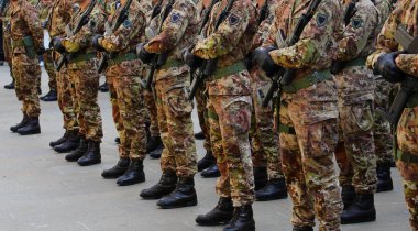 Kamuflaj üniformalı asker müfrezesi geçit töreni ve siyah botlar sırasında saldırı tüfeği.