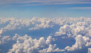 Okyanus aşırı uçarken bir uçaktan gelen tüylü bulutların inanılmaz manzarası.