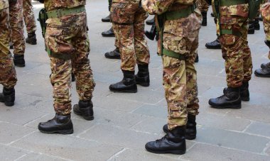 Kamuflaj üniformalı asker botları hazır olda bekliyor.