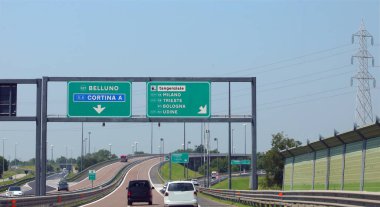 Kuzey İtalya 'daki ünlü CORTINA MILAN BOLOGNA şehirlerine ulaşma talimatlarıyla İtalyan otobanındaki tabelayla kavşakta.