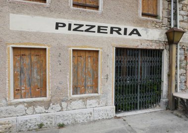 19. covid19 'un neden olduğu ekonomik kriz nedeniyle kentte PIZZERIA metni olan bir restoranın işareti