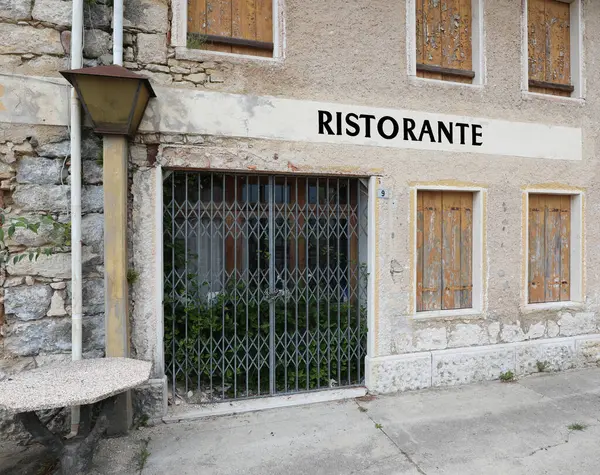 stock image RISTORANTE which means restaurant in italian language that is with the shutters down because it is closed due to the economic crisis