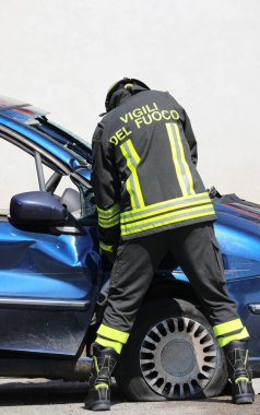 Vicenza, VI, İtalya - 23 Mayıs 2024: Bir araba kazası ve üniforma üzerine İtalyanca metin sonrasında Jaws of Life 'ı kullanarak araba kapısını açmak için korkusuz itfaiyeci