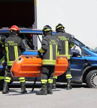 Vicenza, VI, Italy - May 23, 2024: Italian firefighters helping injured man in crashed car after road accident clipart