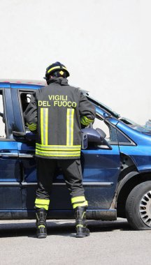 Vicenza, VI, İtalya - 23 Mayıs 2024: Trafik kazası ve üniformalı İtalyanca metin sonrasında kaza yapan arabanın kapısını açan itfaiyeci