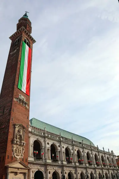 stock image Vicenza, VI, Italy - May 10, 2024: Tower called Torre Bissara with Long Italian Flag and monument palladianan Basilica by ANDREA PALLADIO Architect