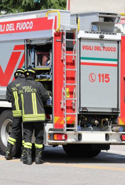 Vicenza, VI, İtalya - 23 Mayıs 2024: İtalyan itfaiyeciler acil durum sırasında itfaiye aracından ekipman alıyorlar