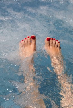 Mükemmel ayakları olan genç bir kadın özel lüks bir tatil köyünde hidromasaj sırasında küvette dinleniyor.