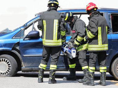 İtfaiyecilerden oluşan bir ekip, Jaws of Life adlı endüstriyel makası kullanarak kazadan sonra kaza yapan araçtaki yaralıları kurtarıyor.