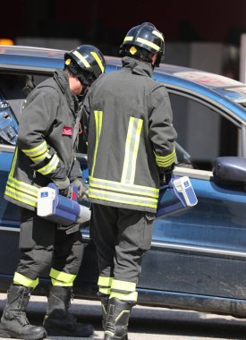 Kazadan sonra yaralananları arabadan kurtarmak için Jaws of Life adlı endüstriyel makası kullanan iki itfaiyeci.