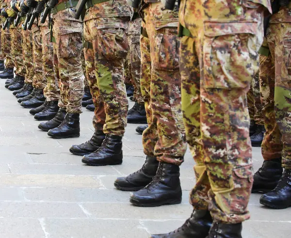 stock image Black combat boots of soldiers in camouflage uniforms standing in formation