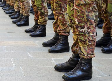 detail of black army boots of soldiers in camouflage uniform during military parade clipart