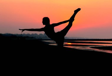 Genç ve zayıf bir kızın siyah silueti jimnastik yapıyor.