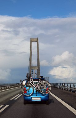 Kuzey Avrupa 'da, Zelanda ve Funen adaları arasında Büyük Kemer Köprüsü adı verilen asma köprüde bisikletli bir araba.