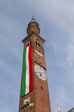 Vicenza, VI, Italy - May 10, 2024: Ancient civic tower called TORRE BISSARA with very Long Italian Flag clipart