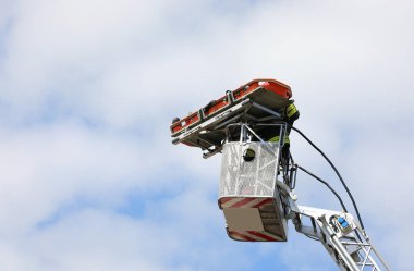 Sedye yaralı kişiyi aşağıda görüldüğü gibi itfaiye aracının sepetine bağladı.