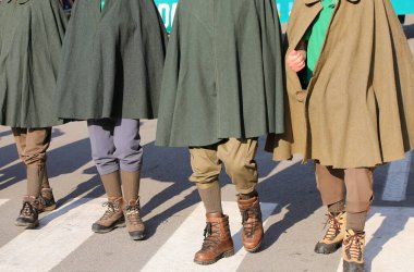 Antik Tabarro pelerinler giyen dört dağ insanı ve Birinci Dünya Savaşı sırasında canlı karakterlerin canlandırıldığı tarihi bir canlandırma sırasında kullanılan eski botlar.