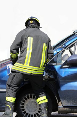 Üniforma giyen itfaiyeci hidrolik makas kullanıyor. Ayrıca Jaws of Life olarak da bilinir. Çarpışan bir arabanın metalini parçalamak ve ağır yaralı bir insanı kurtarmak için.