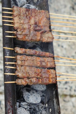 many cooked skewers on the grill with mutton and lamb called ARROSTICINI a typical dish of the cuisine of Italy such as Abruzzo and Molise clipart