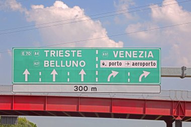 İtalya otobanındaki yol tabelası ve TRIESTE BELLUNO ve VENICE gibi şehirlerin isimleri ve havaalanı yönleri