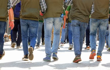 Protesto sırasında kentin sokaklarında yürüyen grevci işçiler görülüyor.