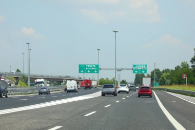 İtalya 'da PASSANTE DI MESTRE adlı otoyol kavşağında Trieste Belluno Venedik' e giden yol işaretleri ve Venedik havaalanı ve birçok araba var.