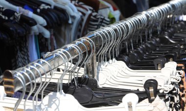 Bir sürü elbise askısı ve metal kancalarla yerel marketteki giyim mağazasında indirimde.