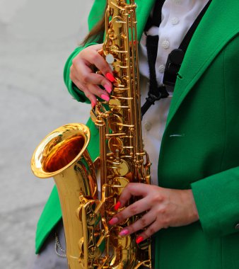 Brass sax player during the musical parade with the music band through the city streets clipart