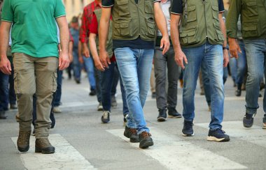 İnsanlar bir protesto sırasında sokaklarda barışçıl bir şekilde yürüyor ve işçilere daha iyi maaş verilmesini talep etmek için grev yapıyorlar.