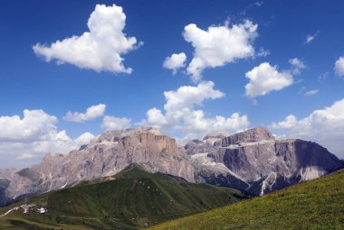 Kuzey İtalya Alpleri 'ndeki Sella Dağı ve küstah Pordoi' nin beyaz bulutlu, nefes kesici panoramik manzarası.