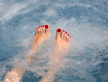 Ayak tırnakları kırmızı, ayak tırnakları ojeli, rahatlatıcı bir masaj seansı sırasında küvette sırılsıklam olmuş.