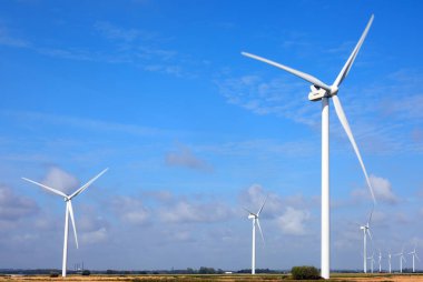 wind turbine with three blades rotating using wind power to produce electricity with zero environmental impact clipart