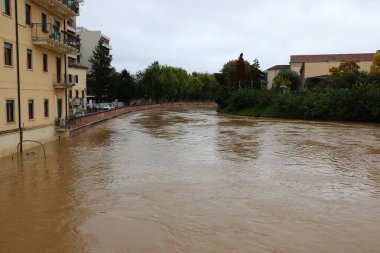 Şiddetli yağışların yol açtığı sel felaketi sırasında İtalya 'nın Vicenza şehrindeki FIUME BACCHIGLIONE adı verilen ev ve binalar ve çamurlu nehir