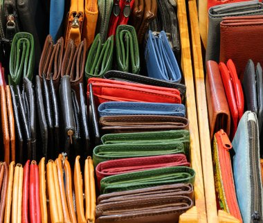Pek çok renkli deri cüzdanın ve el çantalarının arka planı. Deri mağazasında satılık usta bir zanaatkârın el yapımı.