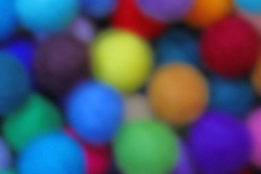 intentionally blurred background of many multicolored wool balls clipart