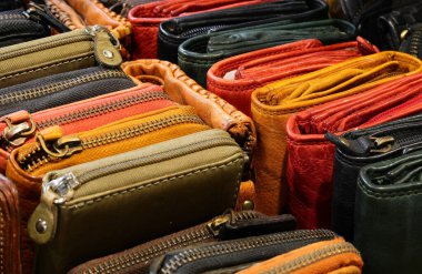 Deri eşya mağazasında satılık yetenekli bir zanaatkar tarafından el yapımı fermuarlı birçok renkli deri cüzdanın arka planı