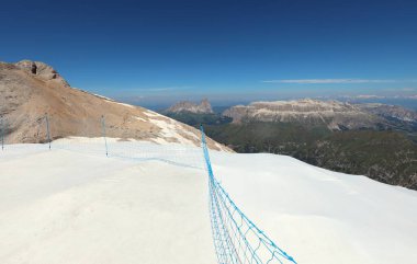 Large white protective sheet over the snow of the Marmolada glacier in northern Italy to shield the ice from summer heat and a safety net for visitors clipart