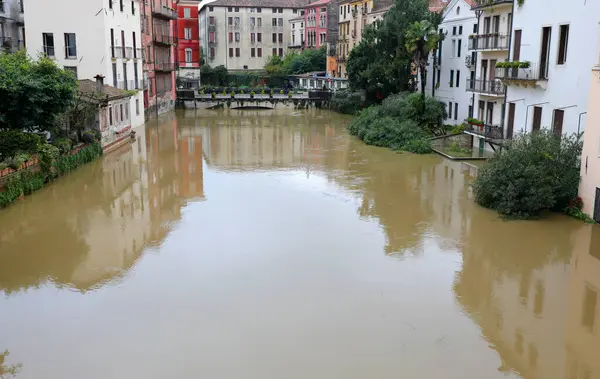 İtalya 'nın kuzeyindeki Vicenza şehrindeki Ponte San Paolo adlı eski köprü ve sel sırasında Retrone nehrinin çarpıcı manzarası.