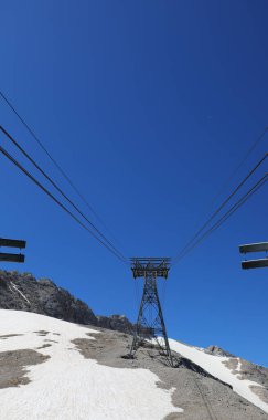 Buzulun üzerinden karla geçen dağın tepesine ulaşmak için büyük bir ropecar direği.