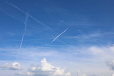 Mavi gökyüzüne karşı pek çok beyaz kimyasal iz var ve bazıları şimdiden küresel bir komployu düşünüyor.