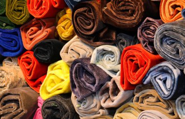 Kumaş mağazasında renkli kumaş ve kadife rulo satılıyor. Amatörler ve özel dikim malzemeleri konusunda uzmanlar.