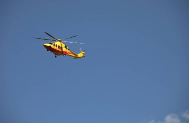 Trento, TN, İtalya - 30 Temmuz 2024: Acil bir durum sırasında havada uçan İtalyan itfaiyecilerin sarı helikopteri
